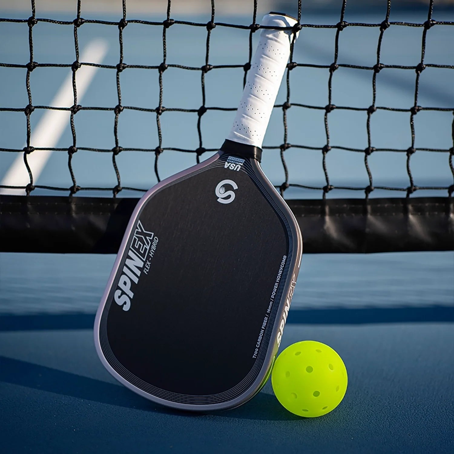 Spinex FLEX Hybrid carbon pickleball paddle with a yellow ball on a blue court, premium set example
