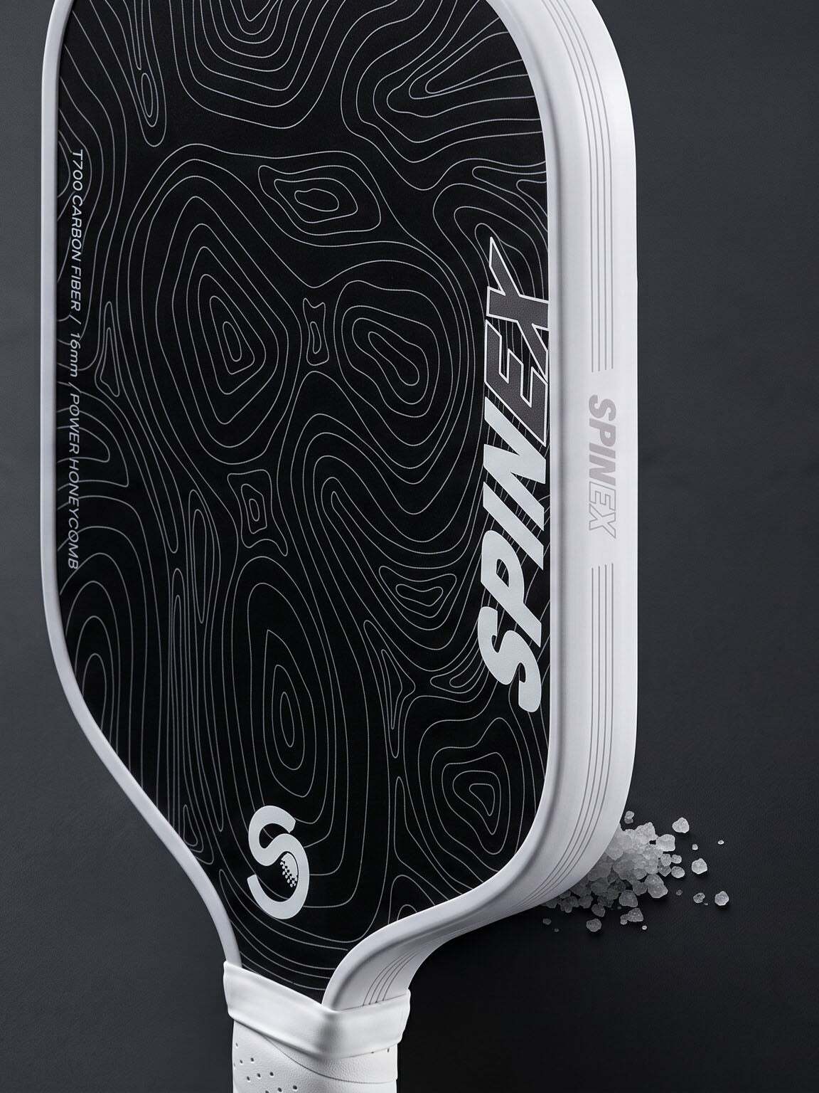 Spinex NOVA Salt Lagoon paddle resting on dark salt crust with scattered salt crystals