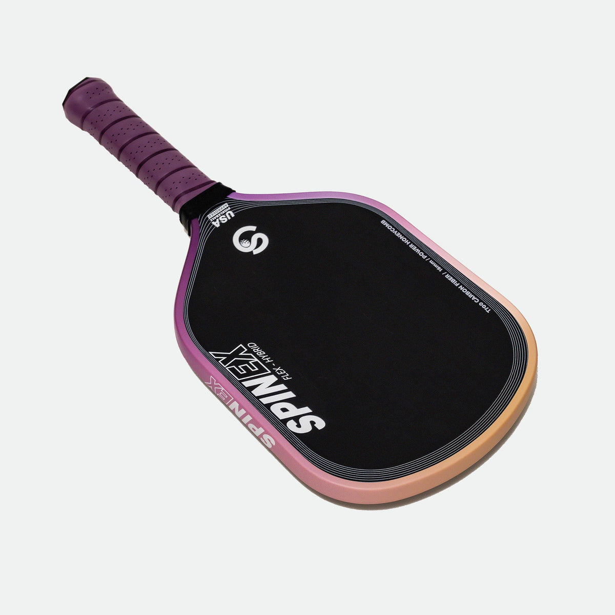 Spinex FLEX Hybrid Storm pickleball paddle laid at an angle showing the purple grip wrap